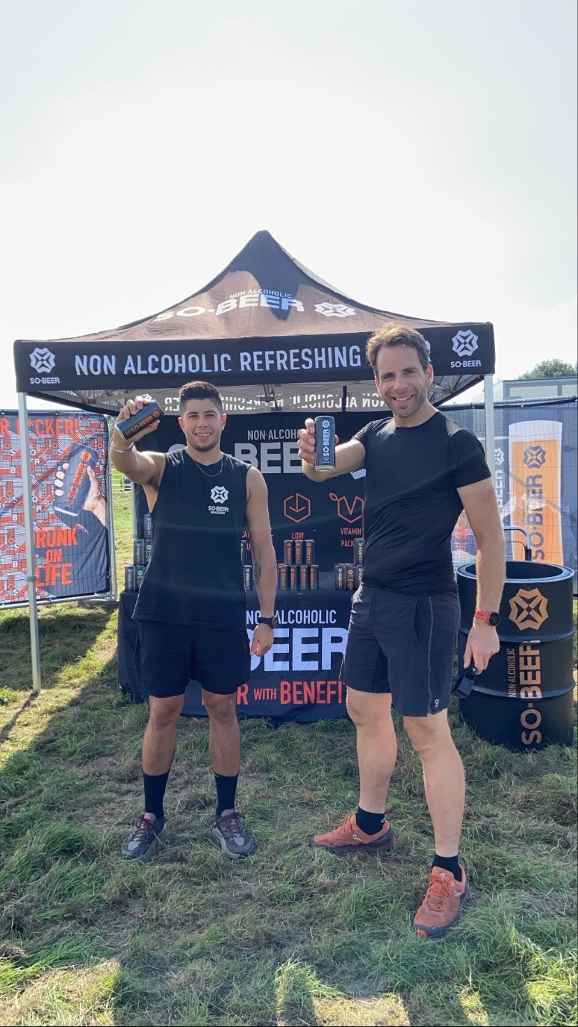 two men holding sobeer can